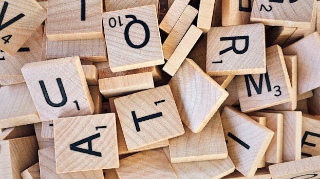 Close-up of wooden Scrabble tiles showcasing letters and numbers for word games.
